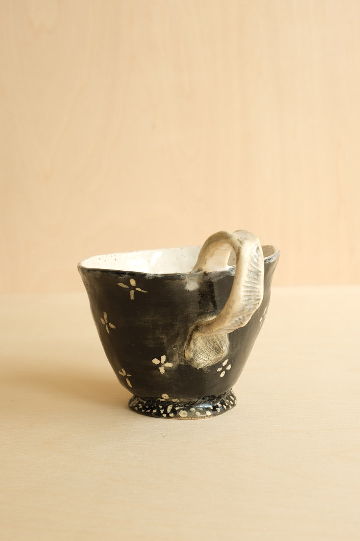 Ceramic cup with floral design on a beige background